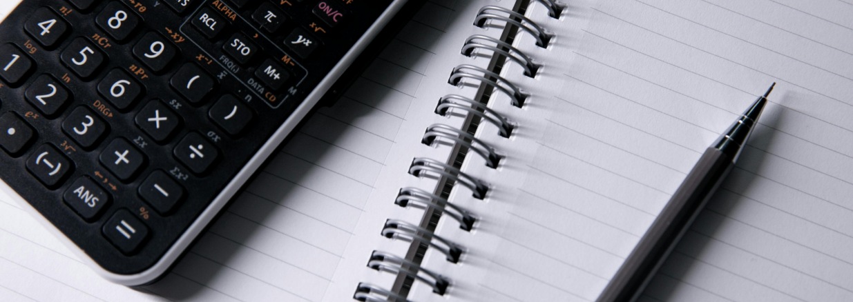 Cuaderno abierto con calculadora y lápiz encima