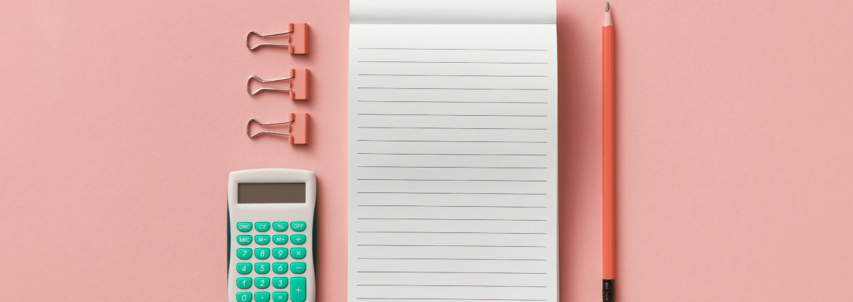 Calculadora, bloc de notas, un lápiz y clips encima de un escritorio