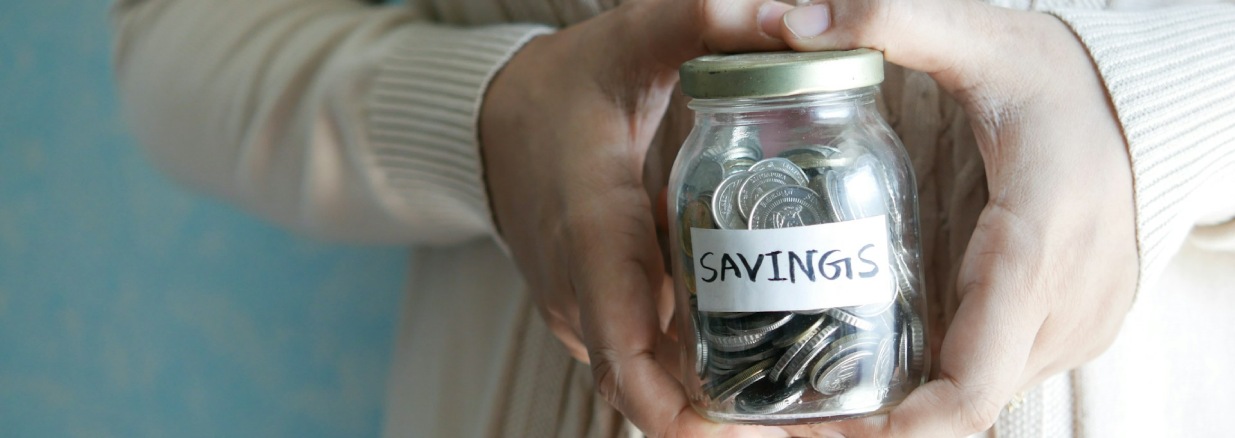 mujer sosteniendo su alcancía con monedas